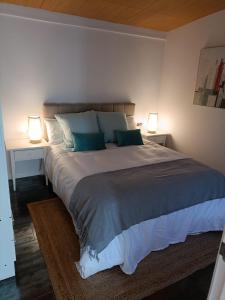 1 dormitorio con 1 cama grande y 2 lámparas en La Casita de Mari, en Moaña
