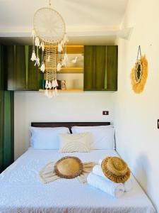1 dormitorio con 1 cama con toallas y lámpara de araña en Sardinian Seaside Retreats, en Badesi
