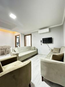 ein Wohnzimmer mit Sofas und einem Flachbild-TV in der Unterkunft Renaissance Apart Hotel in Trabzon