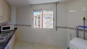 a small kitchen with a window and a sink at Apartamento vistas al mar, segunda línea 3 habitaciones in Sant Carles de la Ràpita +37 photos
