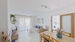 sala de estar con mesa y sofá en Apartamento vistas al mar, segunda línea 3 habitaciones, en Sant Carles de la Ràpita
