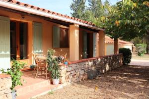 a house with a stone wall and a patio at La Maison de Blu in Lorgues