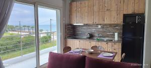 a kitchen with a table with chairs and a refrigerator at sea breeze epivates in Neoi Epivates +9 photos