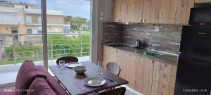 a kitchen with a table with chairs and a refrigerator at sea breeze epivates in Neoi Epivates