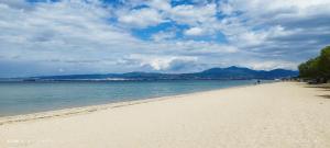 a beach with a person walking on the sand at sea breeze epivates in Neoi Epivates