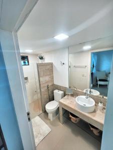 een badkamer met een toilet, een wastafel en een spiegel bij Casa Sonho da praia beira-mar 04 suítes in Barra de Santo Antônio