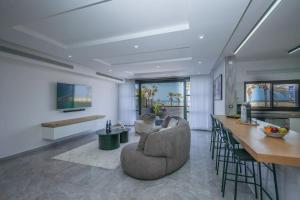 uma sala de estar com um sofá e uma mesa em וילת פאר בקו ראשון לים em Ashdod