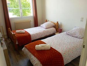 a bedroom with two beds with towels on them at gite du puits in Bernières-dʼAilly