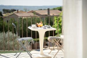 una mesa blanca con 2 sillas en el balcón en Hôtel Le Pré Saint Michel, en Manosque