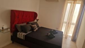 a bedroom with a large bed with a red headboard at St Julian's Central Paceville Apartments in St Julian's
