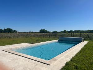 ein Pool auf einem Feld mit einem Zaun in der Unterkunft Charmante petite maison avec piscine in Monguillem
