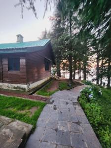 a house with a walkway in front of a yard at Jungle Stay Dalhousie(Kalatop) in Dalhousie