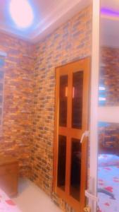 um quarto com uma parede de tijolos e uma porta em La fierté em Ziguinchor