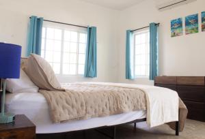 a bedroom with a bed and two windows at The Sunflower Villa in Grand Turk