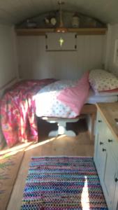 a small bedroom with a bed and a table at Duck Hut in Dundon