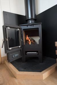 um fogão a lenha com uma televisão num quarto em Duck Hut em Dundon