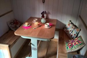uma mesa de madeira com duas chávenas de café em Duck Hut em Dundon