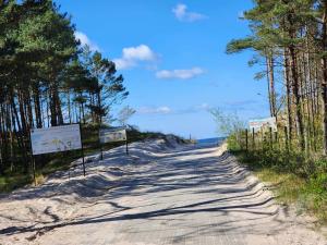 un camino de tierra con árboles a ambos lados en Przy Wydmie, en Mrzeżyno