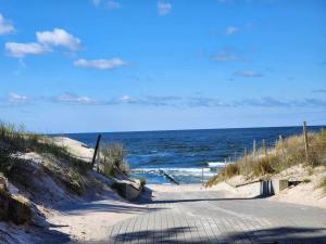 un camino que conduce al océano en una playa en Przy Wydmie, en Mrzeżyno