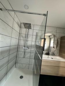 a shower with a glass door in a bathroom at Maison aux pieds du circuit de Mirecourt in Baudricourt +6 photos