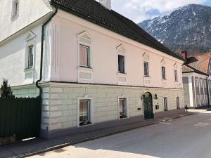 een wit gebouw met een groene deur in een straat bij Stiftsblick in Spital am Pyhrn