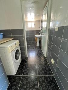 a bathroom with a washing machine and a sink at Villa Yasmine in Djerba