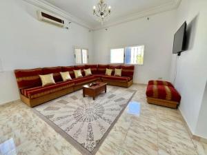 a living room with a couch and a tv at Villa Yasmine in Djerba