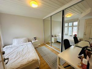 a bedroom with a bed and a desk and a table at Sjarmerende bolig like ved togstasjonen in Bergen