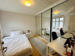 een slaapkamer met een bed, een bureau en een tafel bij Sjarmerende bolig like ved togstasjonen in Bergen