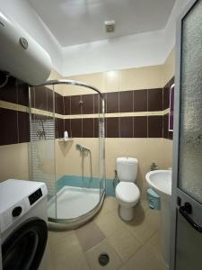 uma casa de banho com um chuveiro, um WC e um lavatório. em Solei Apartments em Saranda