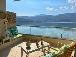 balcón con mesa y vistas al agua en Beach House in Itea-Delphi en Itea
