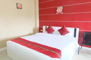 een slaapkamer met een wit bed met rode muren bij Phuket Andaman Place ภูเก็ตอันดามันเพลส in Phuket