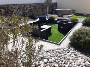 einen Garten mit schwarzen Stühlen und grünem Gras in der Unterkunft Location Logement Au Cœur du Vignoble et Spa in La Chapelle-Heulin