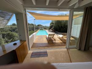 a room with a view of a swimming pool with a window at Luxury studio with private pool in Binisafua