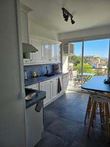 uma cozinha com armários brancos e uma mesa com vista em Les Sables - 75 m2 - 4 stars tourism Panoramic View em Antibes