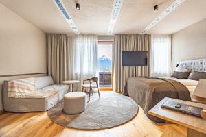 Habitación de hotel con cama y sofá en Hotel Neue Post, en Zell am See