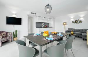 Un comedor y una sala de estar con mesa y sillas. en Bellavista, en Arzachena