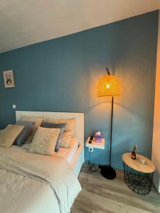 Dormitorio azul con cama y lámpara en Studio Provençal - Proche d'Aix, en Éguilles