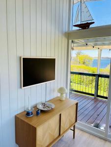 LøgstrupにあるBeautiful summerhouse with full View of the fjordのリビングルーム(壁に薄型テレビ付)