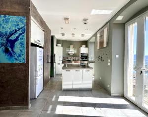 uma cozinha com electrodomésticos brancos e uma grande janela em Maison village Golf de Calvi vue mer em Lumio