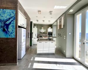 a kitchen with white appliances and a large window at Bella Vista - Duplex d'exception avec terrasse suspendue et vue panoramique sur la baie de Calvi in Lumio