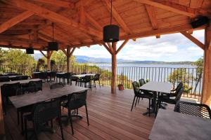 a patio with tables and chairs and a view of the water at Résidence U Paviddonu in Porto-Vecchio