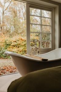 a bath tub sitting in front of a window at B&B Sur Place in Huizen