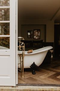 a white bath tub sitting in a room at B&B Sur Place in Huizen