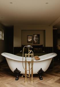 B&B Sur Place في هاوسن: حوض استحمام في غرفة مع سرير