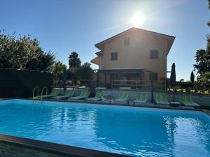 a swimming pool with lounge chairs and a building at Casale Ermo Colle in Recanati