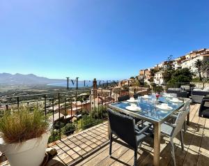 a table and chairs on a balcony with a view at Bella Vista - Duplex d'exception avec terrasse suspendue et vue panoramique sur la baie de Calvi in Lumio
