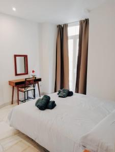 um quarto com uma cama com duas almofadas em Viktory Apartments em Valladolid