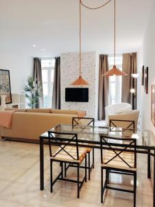 uma sala de estar com um sofá, uma mesa e cadeiras em Viktory Apartments em Valladolid