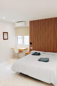 um quarto com uma cama branca e uma parede de madeira em Viktory Apartments em Valladolid